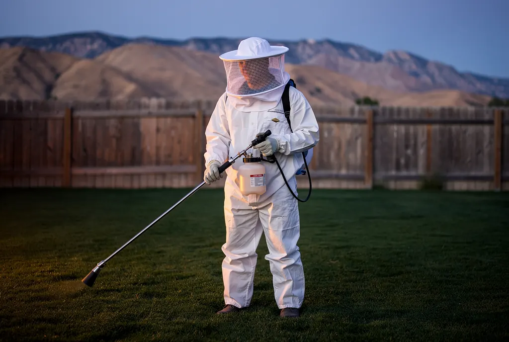 Suited technician preparing dusk treatment of a ground nest in Salt Lake City